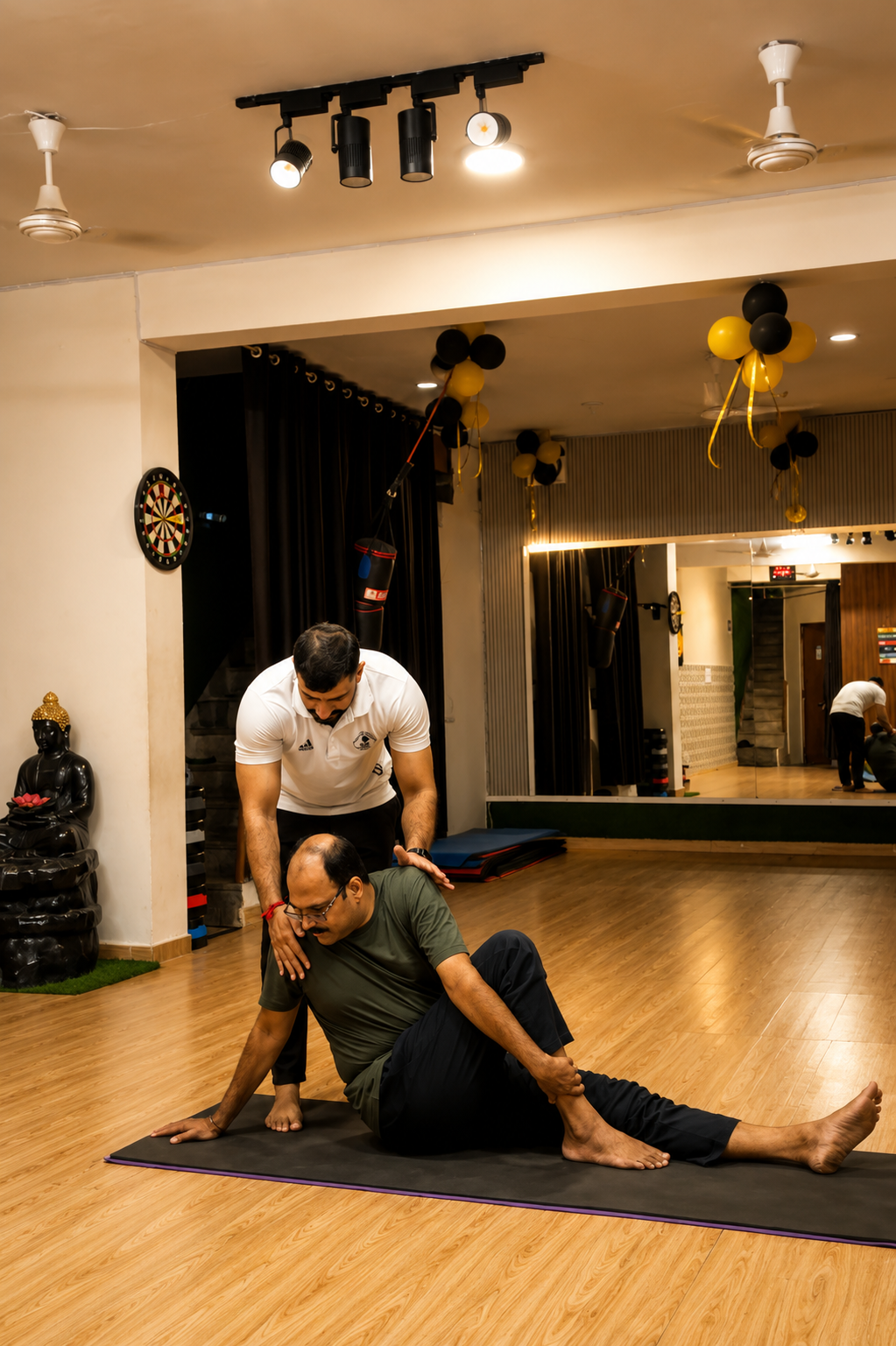 Sudhir adjusting a student in a seated spinal twist