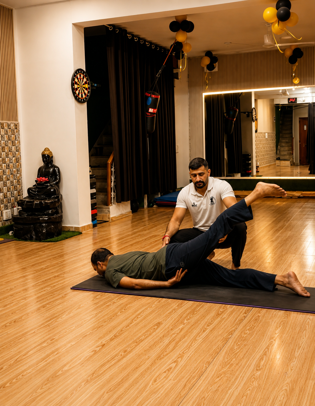Sudhir supporting a student through a supported leg stretch